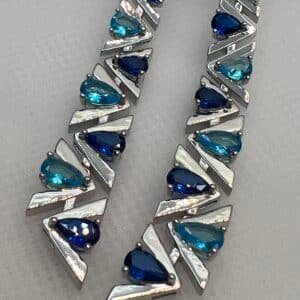 Pendientes largos con circonitas de color azul rodiados en oro blanco