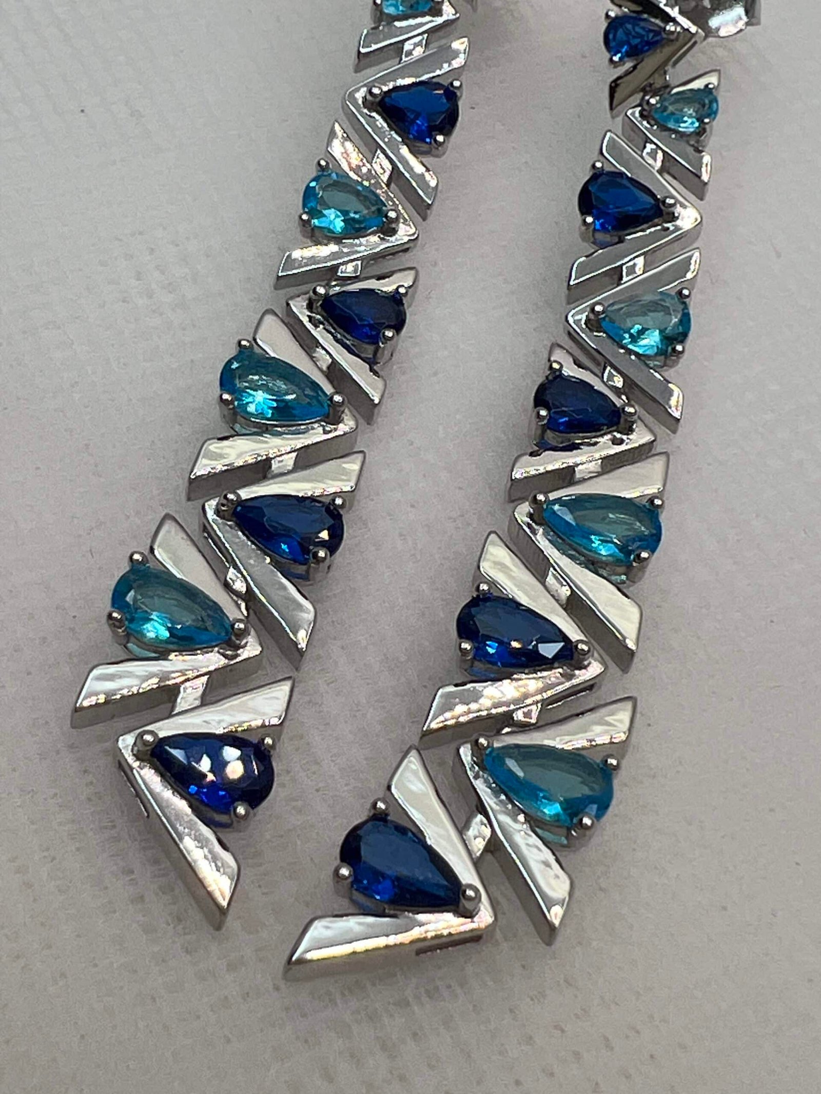 Pendientes largos con circonitas de color azul rodiados en oro blanco