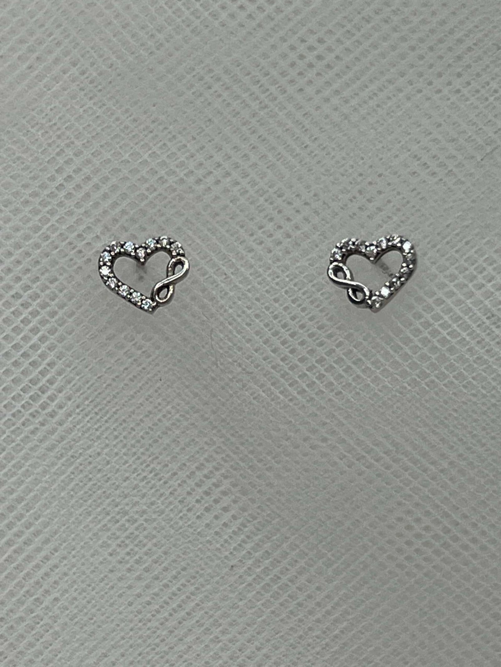 Pendientes corazones con infinitos de plata rodiados en oro blanco y circonitas