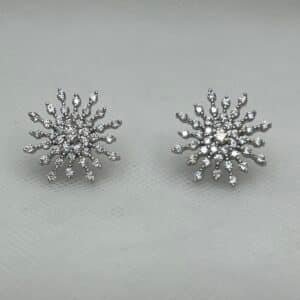 Pendientes de botón con forma de copo de nieve con circonitas rodiado en oro blanco.