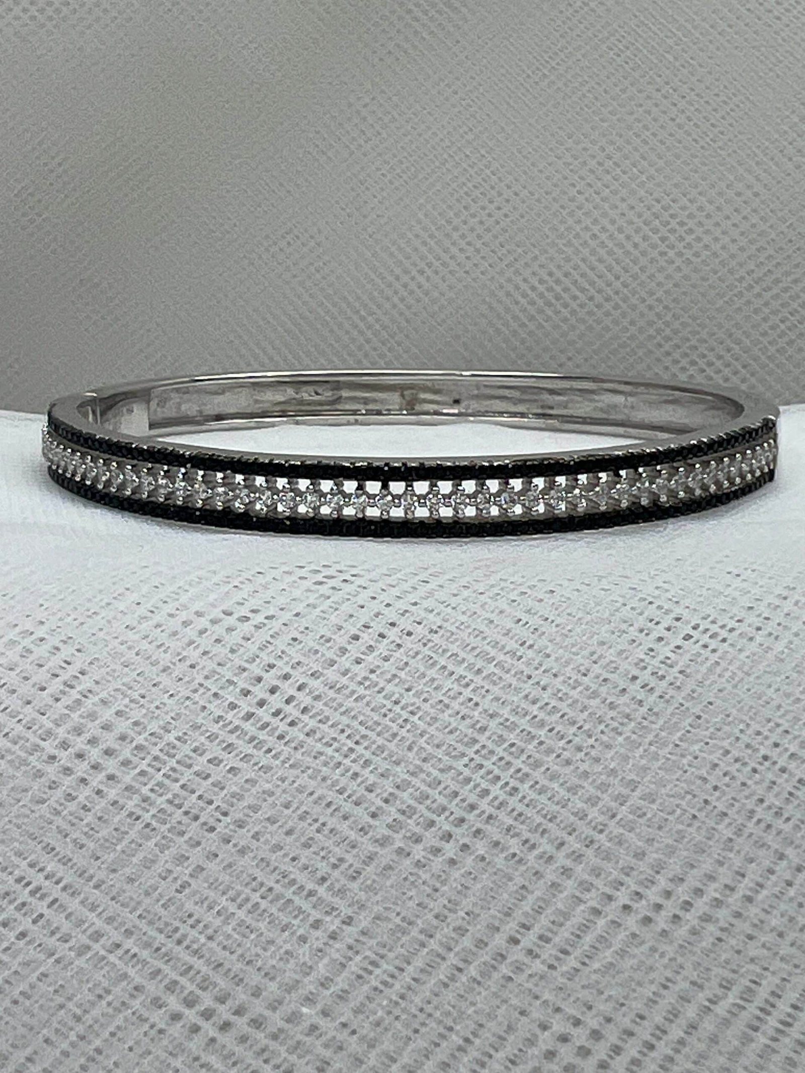 Esclava de plata con circonitas blancas y negras rodidada en oro blanco