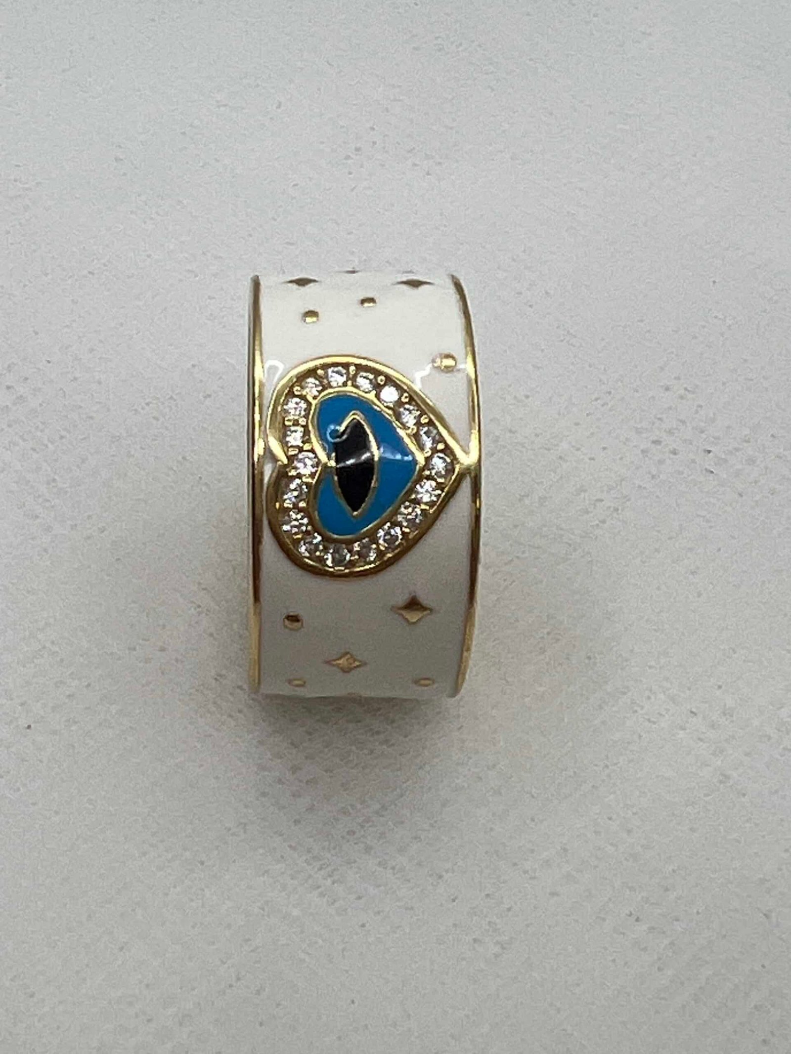 Anillo de plata chapada en oro amarillo y esmalte blanco.