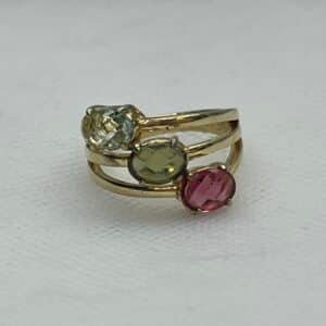 Tres anillos unidos chapados en oro amarillo con circonitas de colores.