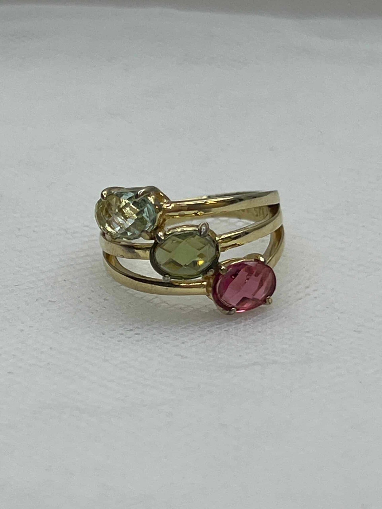 Tres anillos unidos chapados en oro amarillo con circonitas de colores.