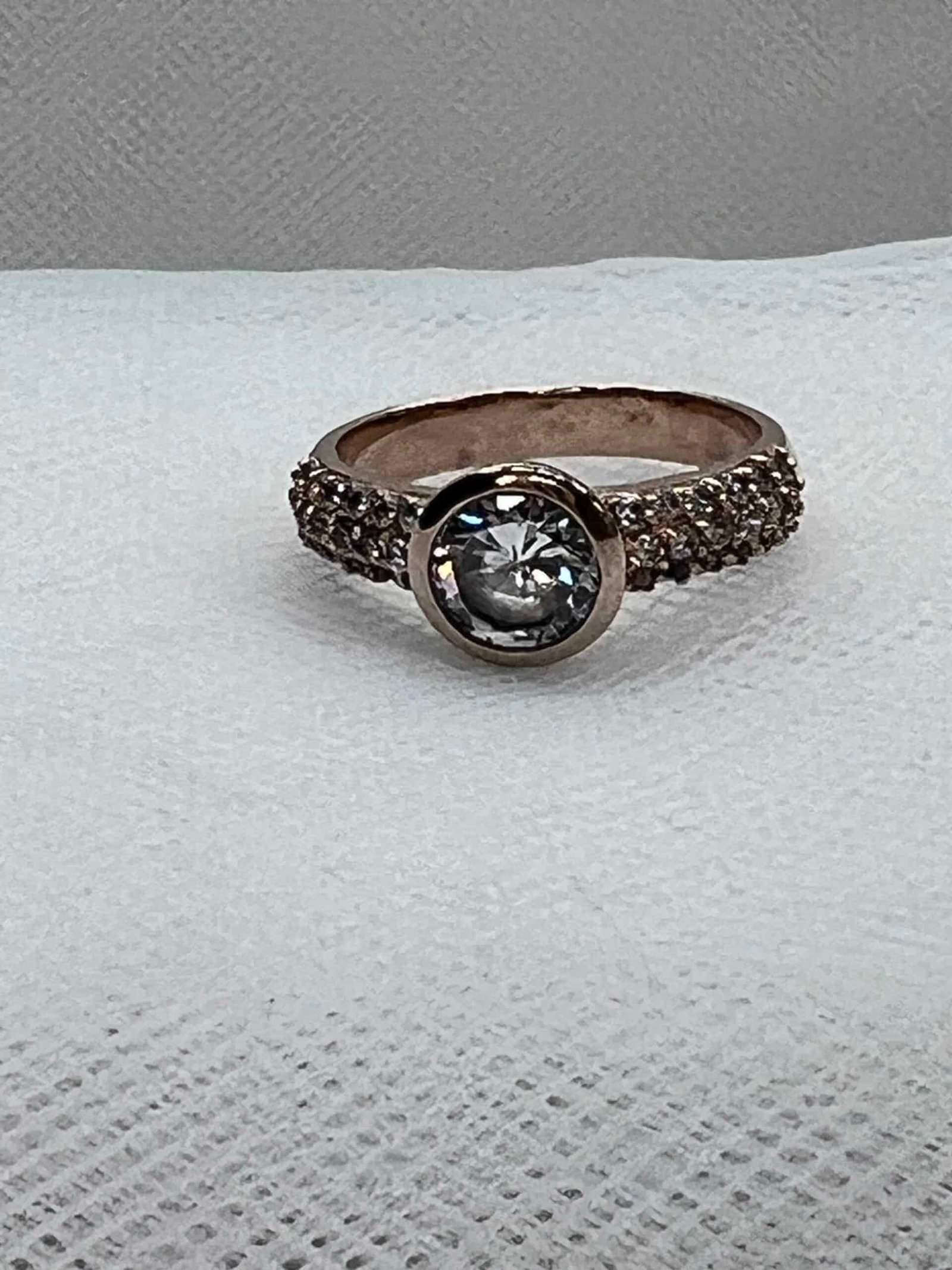 Solitario chapado en oro rosa con pave de circonitas y circornita central.