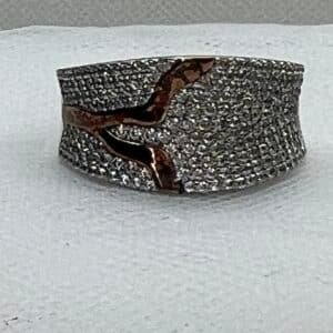 Anillo de plata rodiado en oro blanco con adorno en oro amarillo y pave de circonitas.