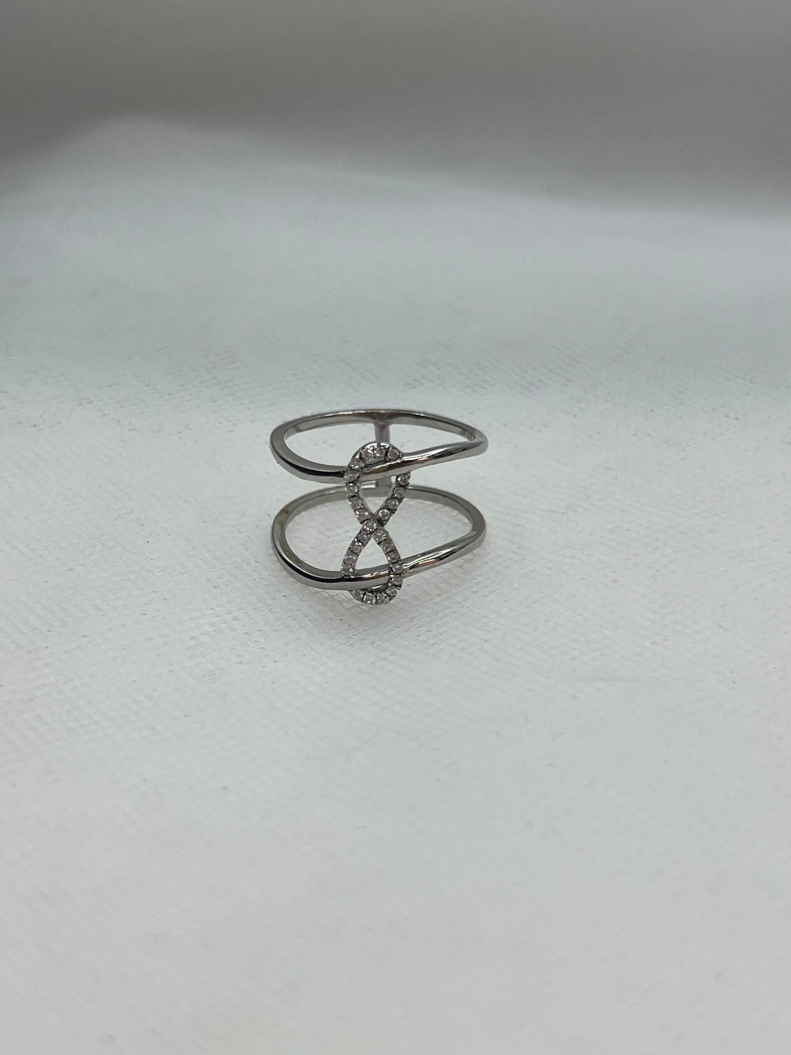 Anillo de plata rodiado en oro blanco con simbolo de infinito de circonitas.