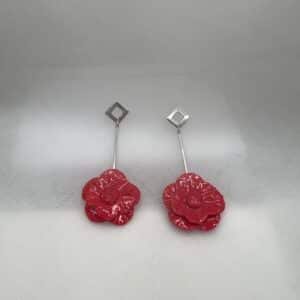 Pendientes largos de acero con flores de porcelana rojas.