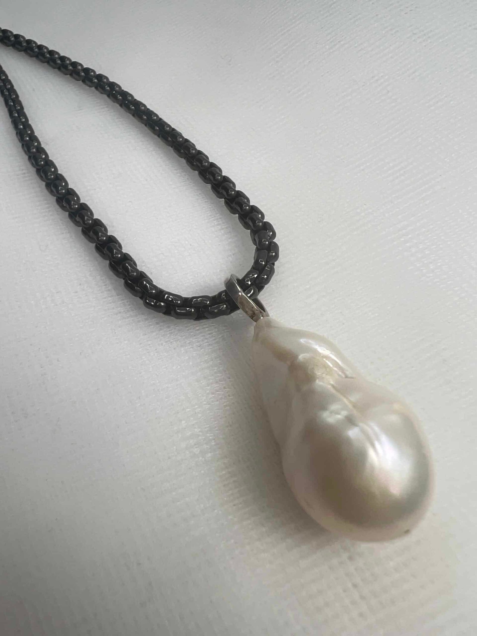 Colgante de perla natural con asa para colgar de plata.