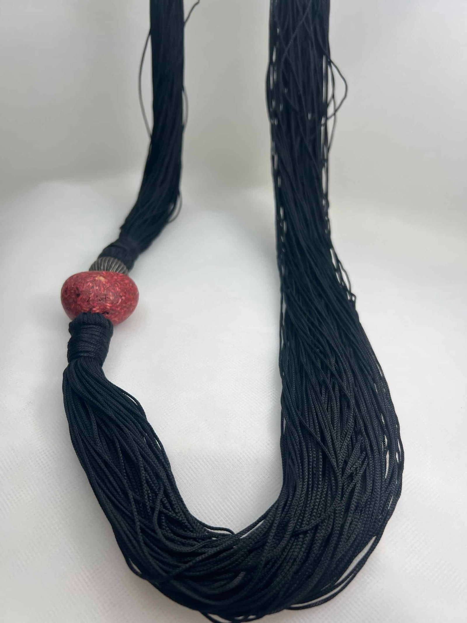 Collar de hilos de macrame con adorno de corazon y bola metalica.