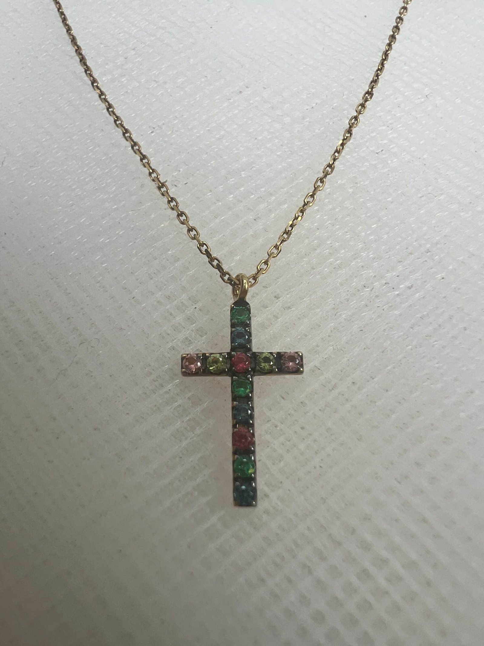 Cadena de oro amarillo con cruz de zafiros de colores.