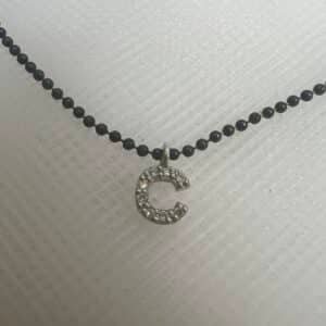 Collar de plata negra con inical de oro blanco con brillantes.