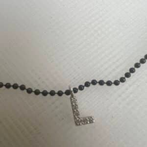 Collar de plata negra con inicial de oro blanco con brillantes.