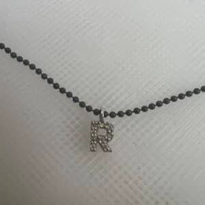 Collar de plata negra con inicial de oro blanco y brillantes.