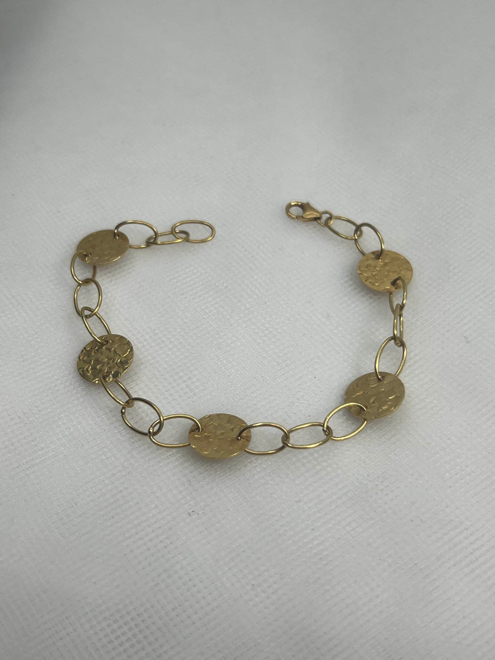 Pulsera de oro amarillo co circulos martelados y eslabones.