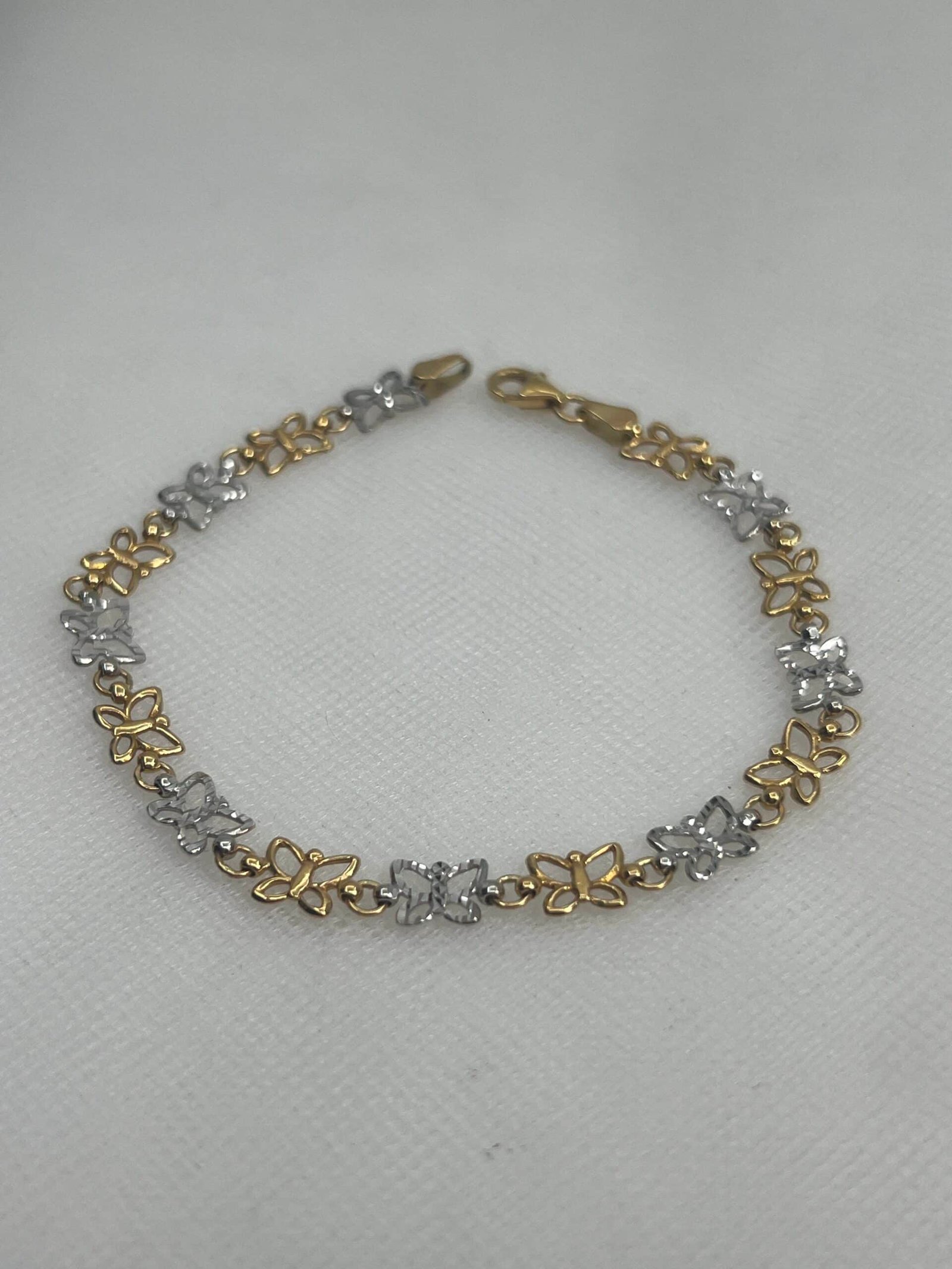 Pulsera de oro con mariposas de oro blanco y amarillo.