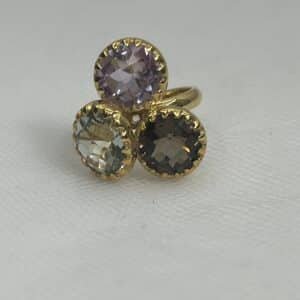Anillo de oro amarillo con piedras naturales olivina cuarzo fume y amatista.