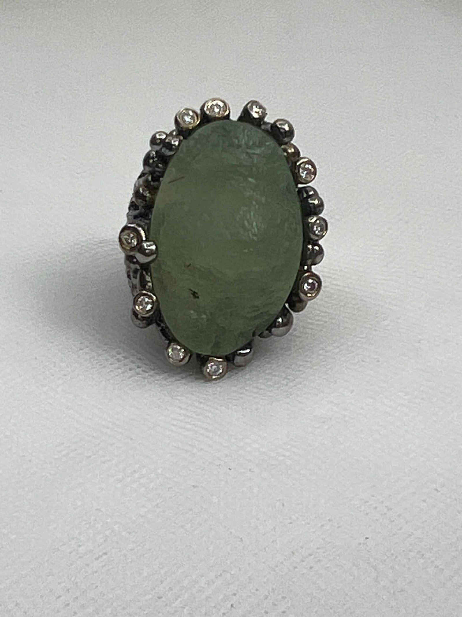 Anillo de plata envejecida con prenita natural en bruto y circonitas.
