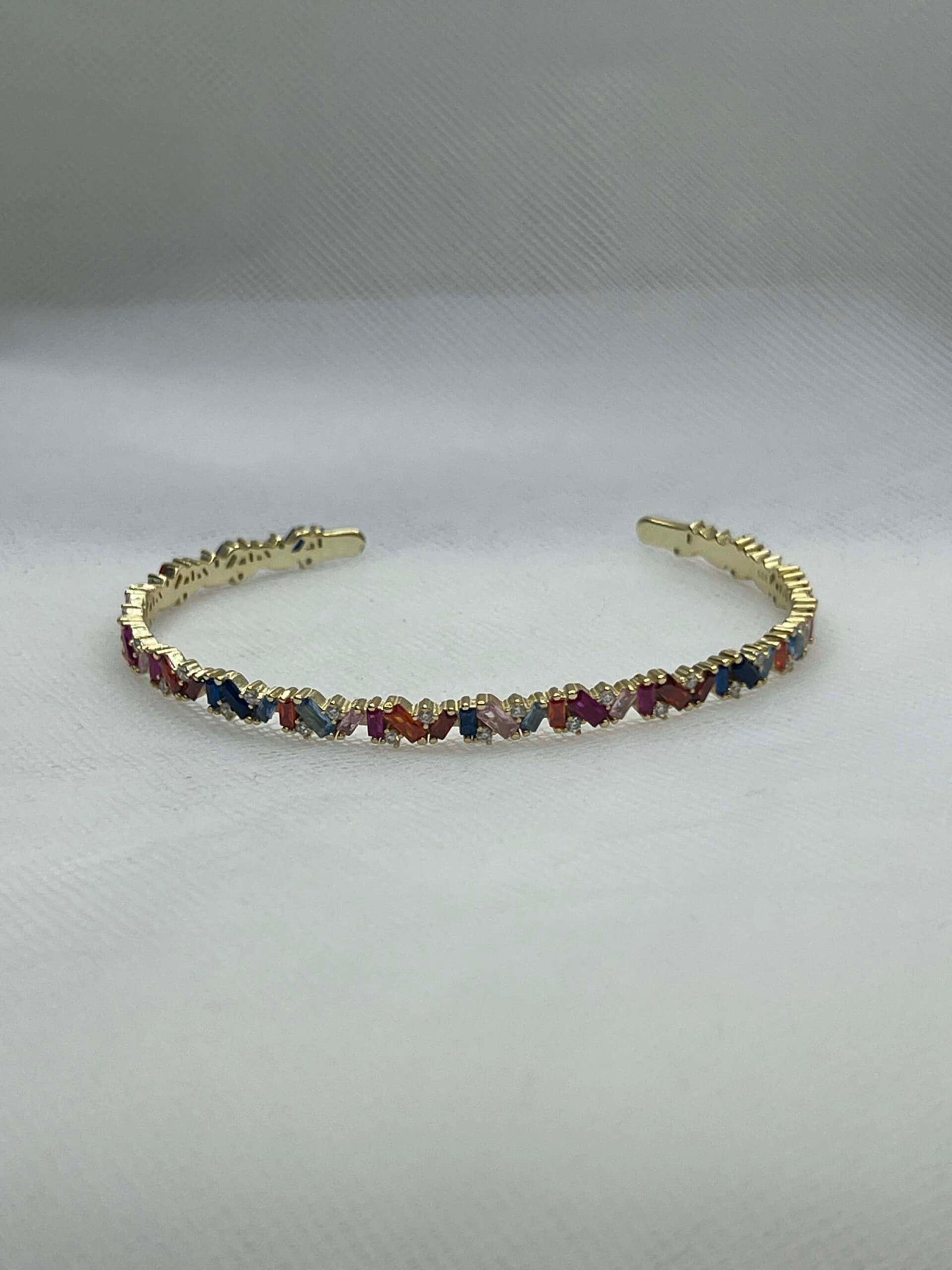 Esclava de plata chapada en oro con circonitas de colores.
