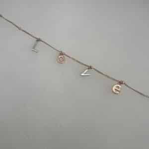 Pulsera de plata chapada en oro rosa con letras.