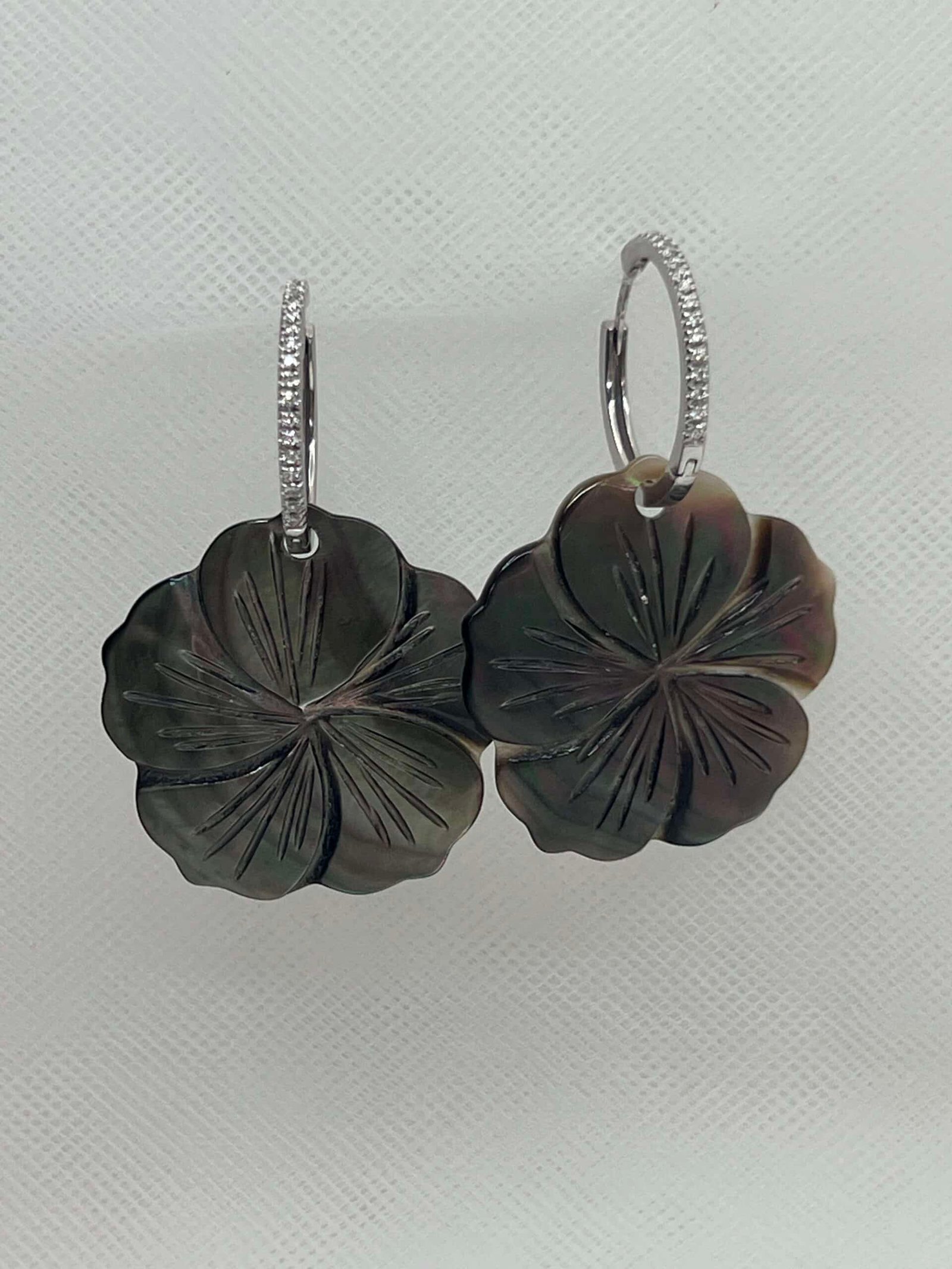 Aros de oro blanco con brillantes y flores de nacar grises.