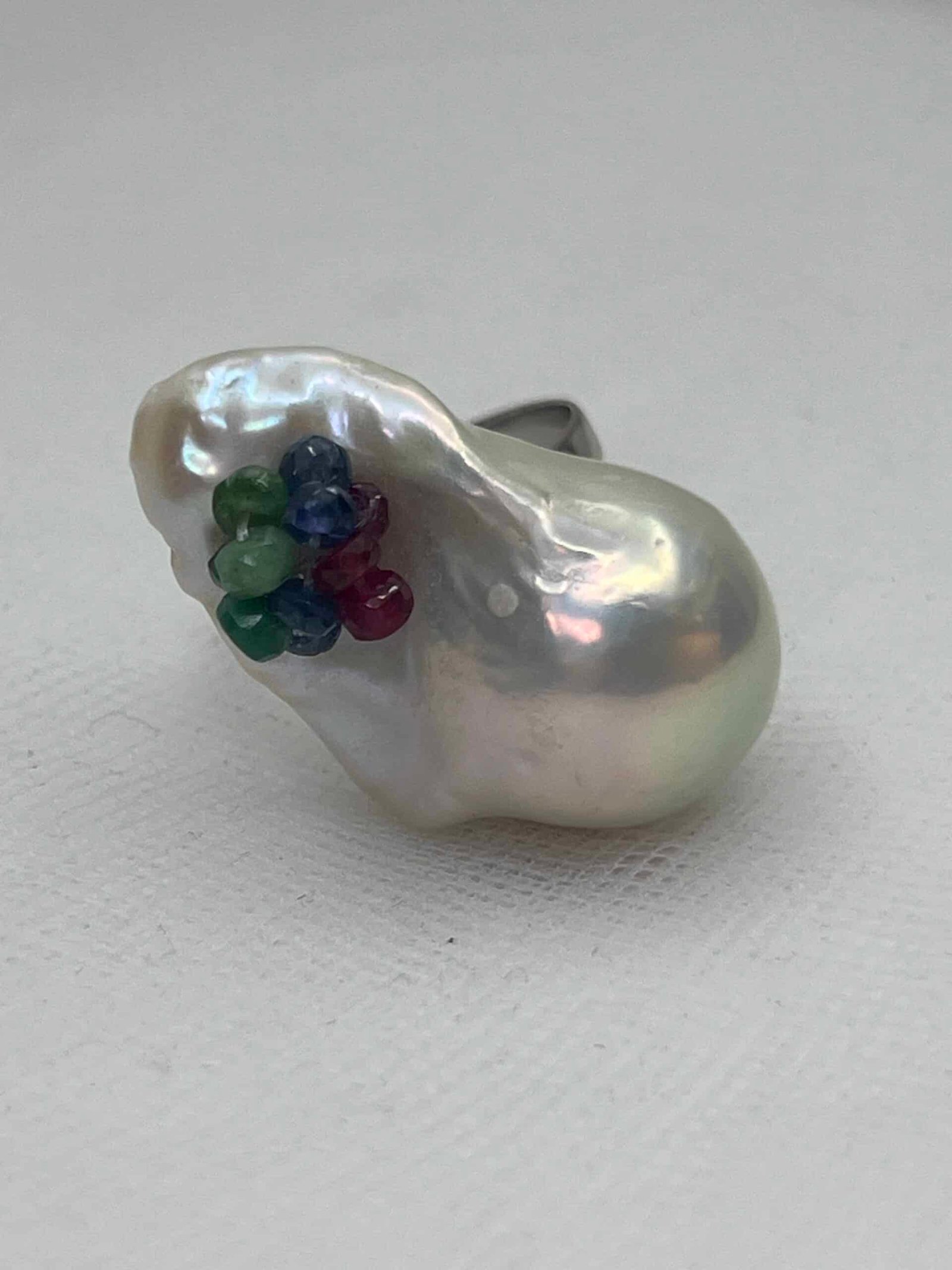 Anillo de oro blanco con perla natural y zafiros de colores.