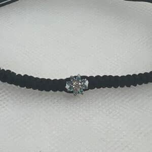 Pulsera de macrame de color negro con roseton de oro blanco con aguamarinas y brillante.