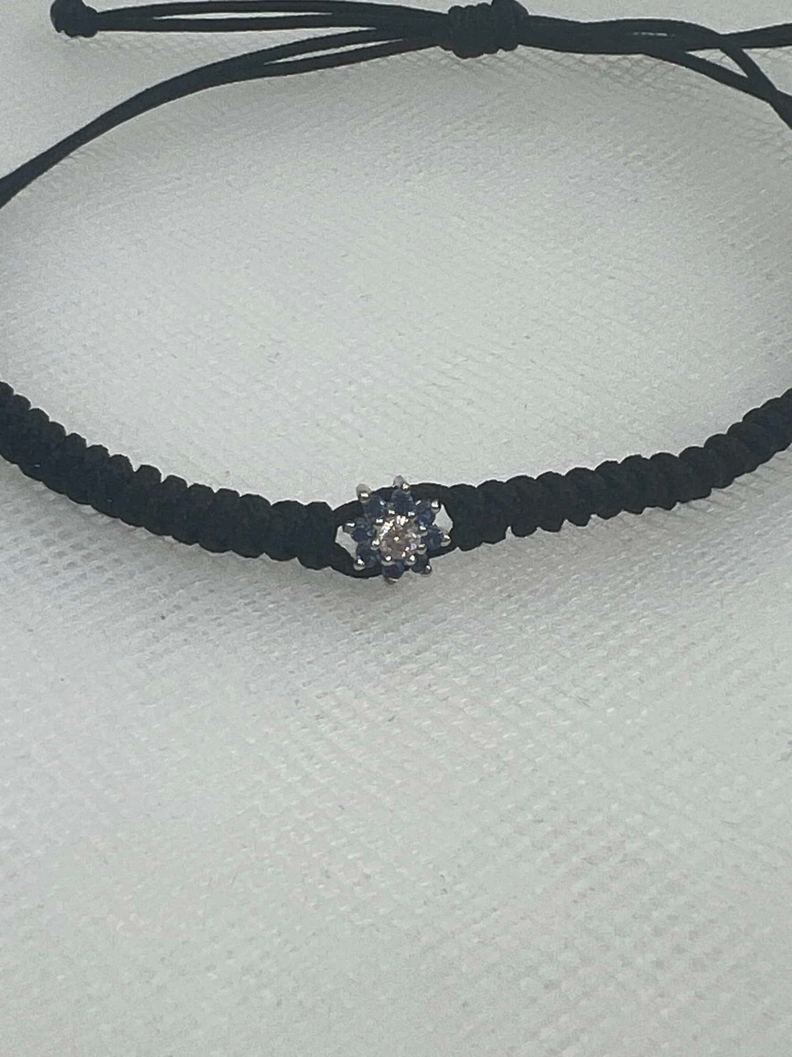 Pulsera de macrame de color negro con roseton de zafiros y brillante.