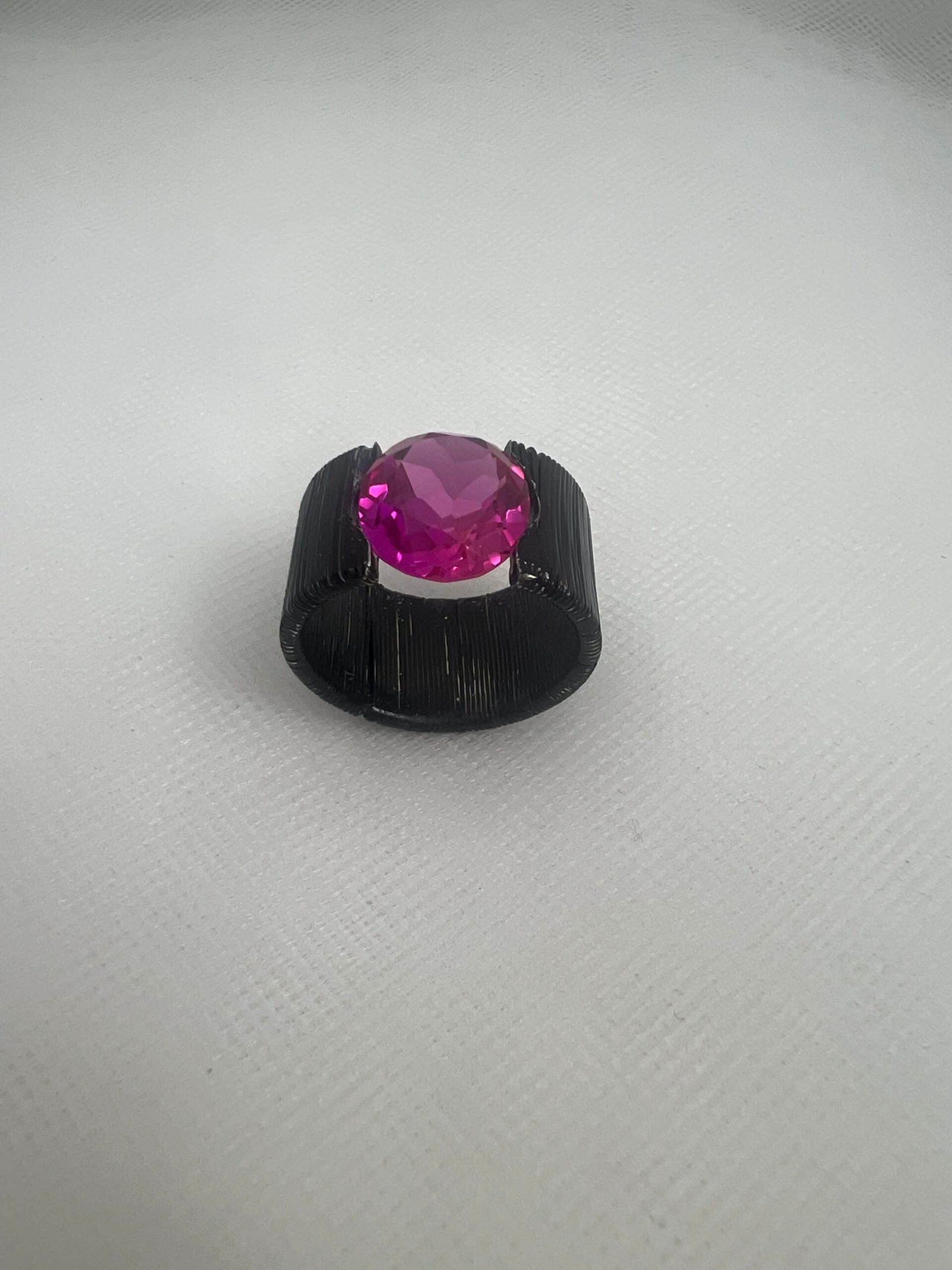 Anillo de bronce esmaltado negro con circonita de color rosa.