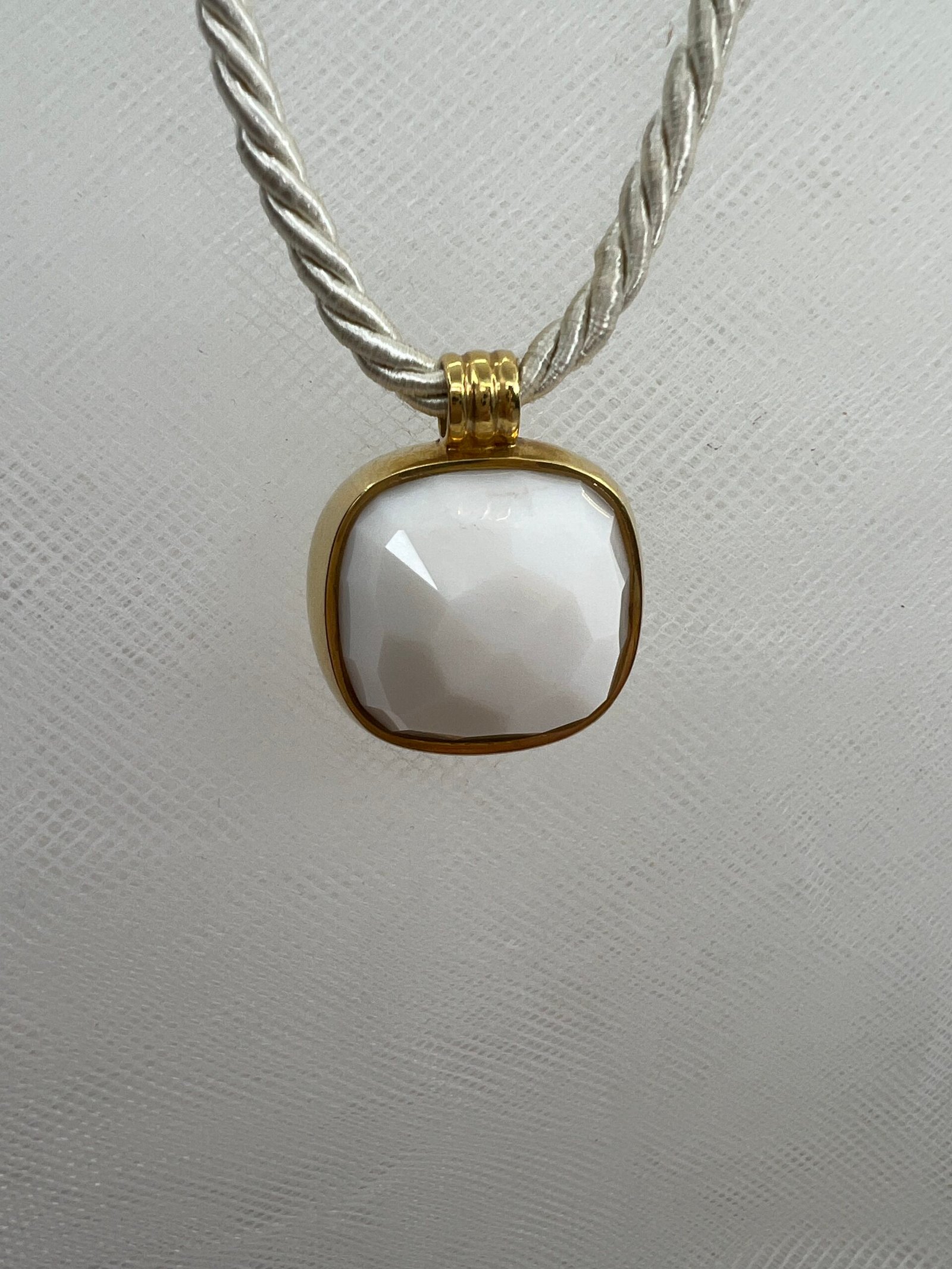 Colgante de oro amarillo con agata natural blanca facetada.