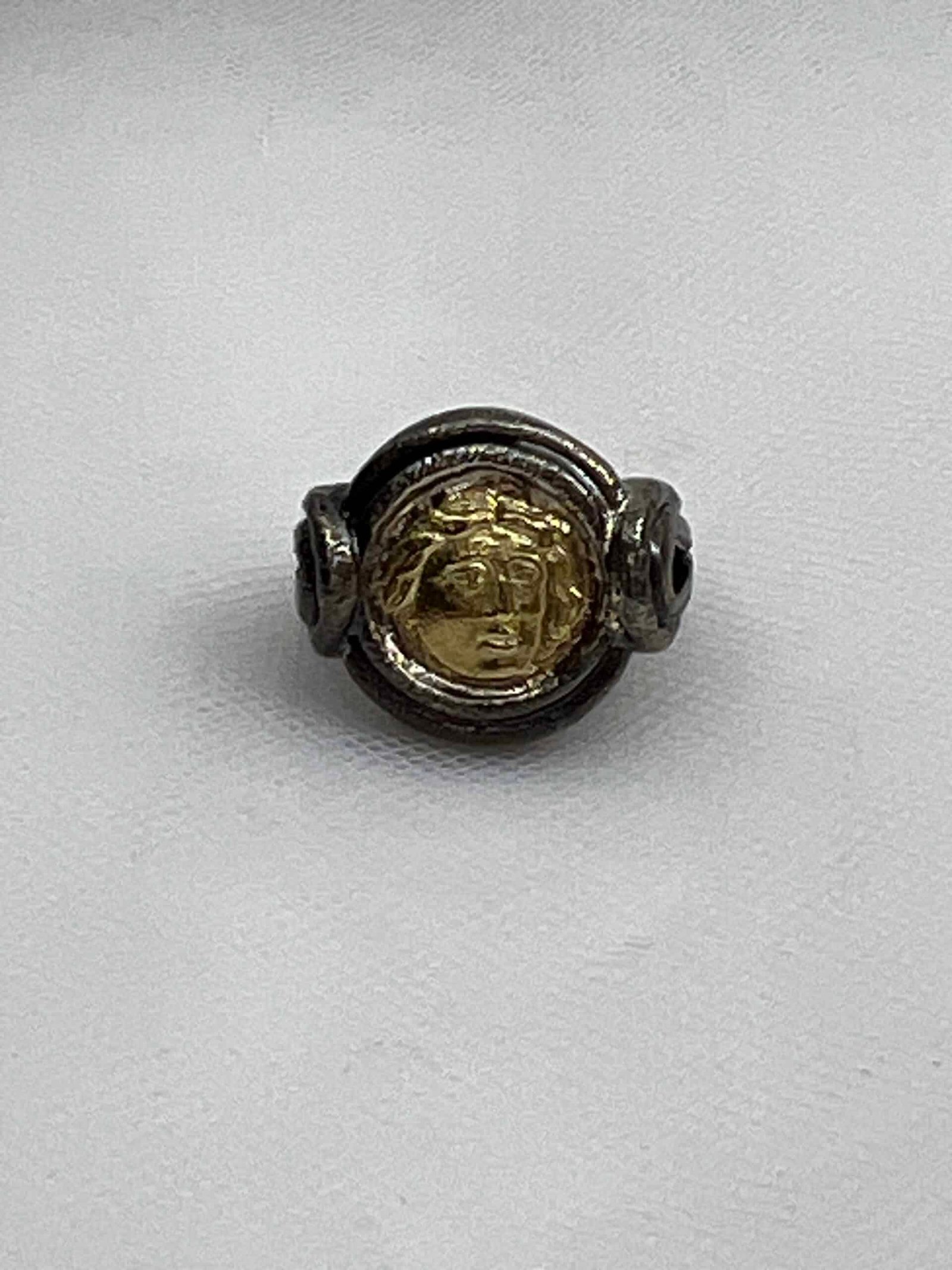 Anillo de plata negra con moneda de imitacion de oro.