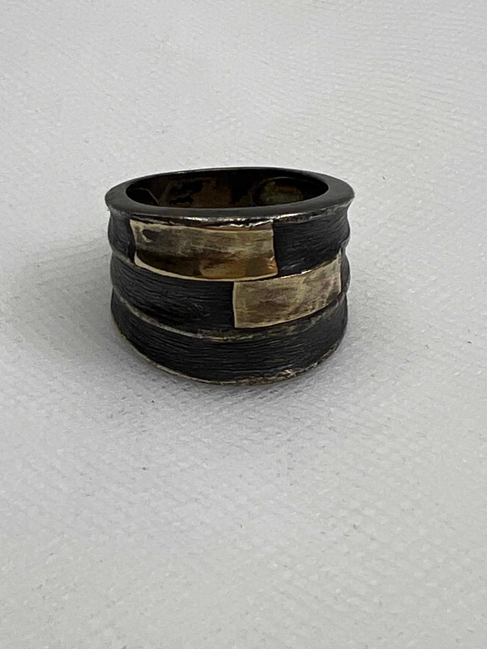 Anillo plata negra con oro amarillo.