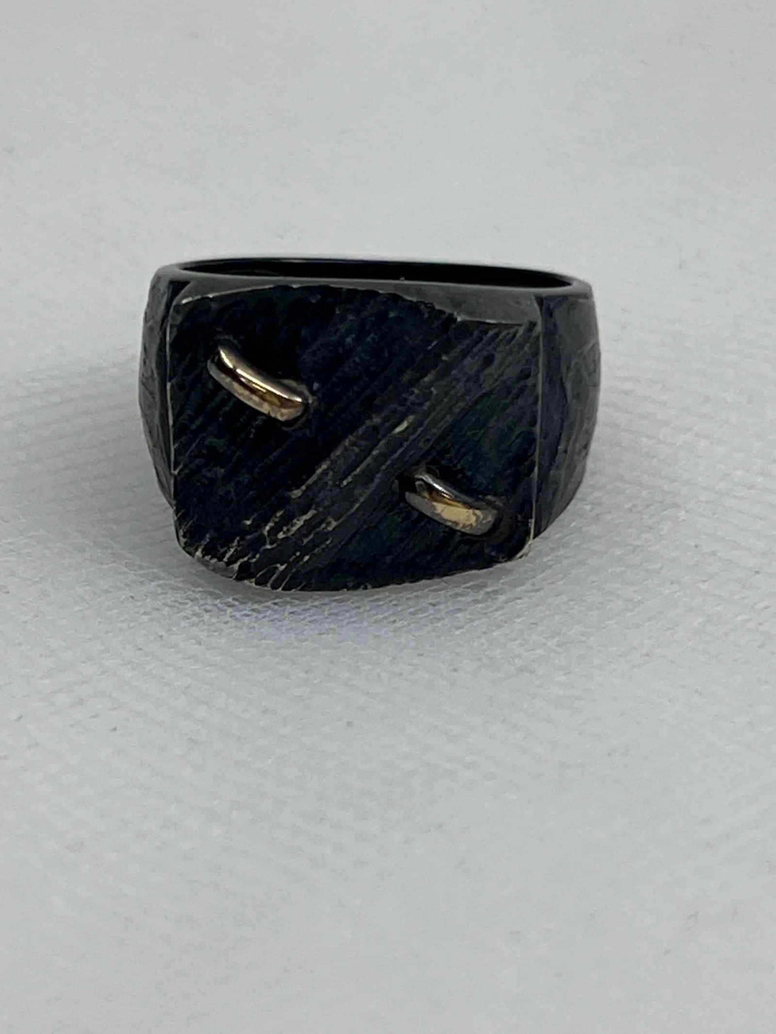 Anillo de plata negra con motivos de oro amarillo.