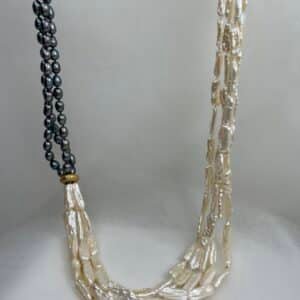 Collar de perlas naturales blancas y grises con entrepieza de oro matizado.