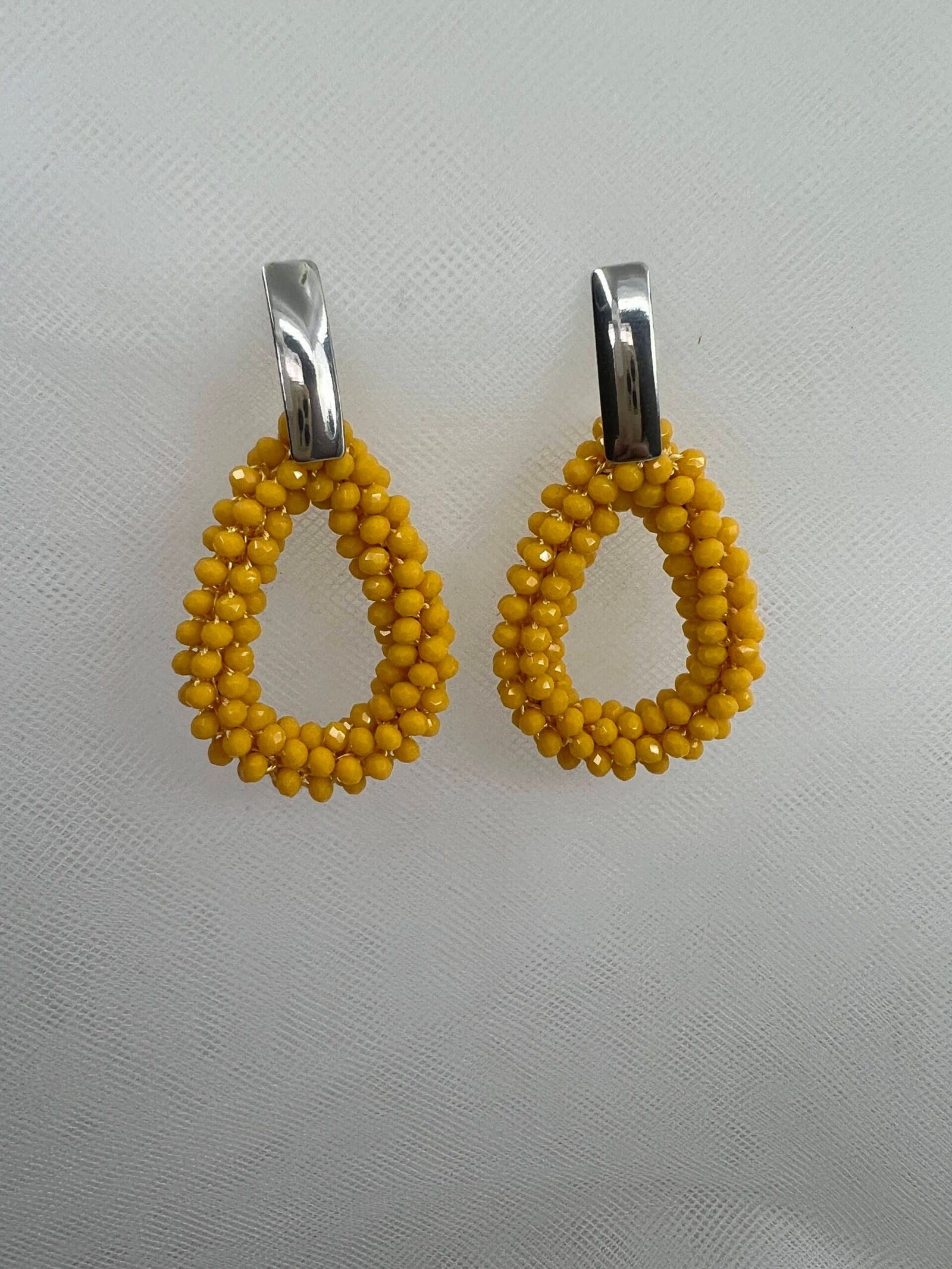 Pendientes largos de acero con colgantes de cuentas de cristal amarillas.