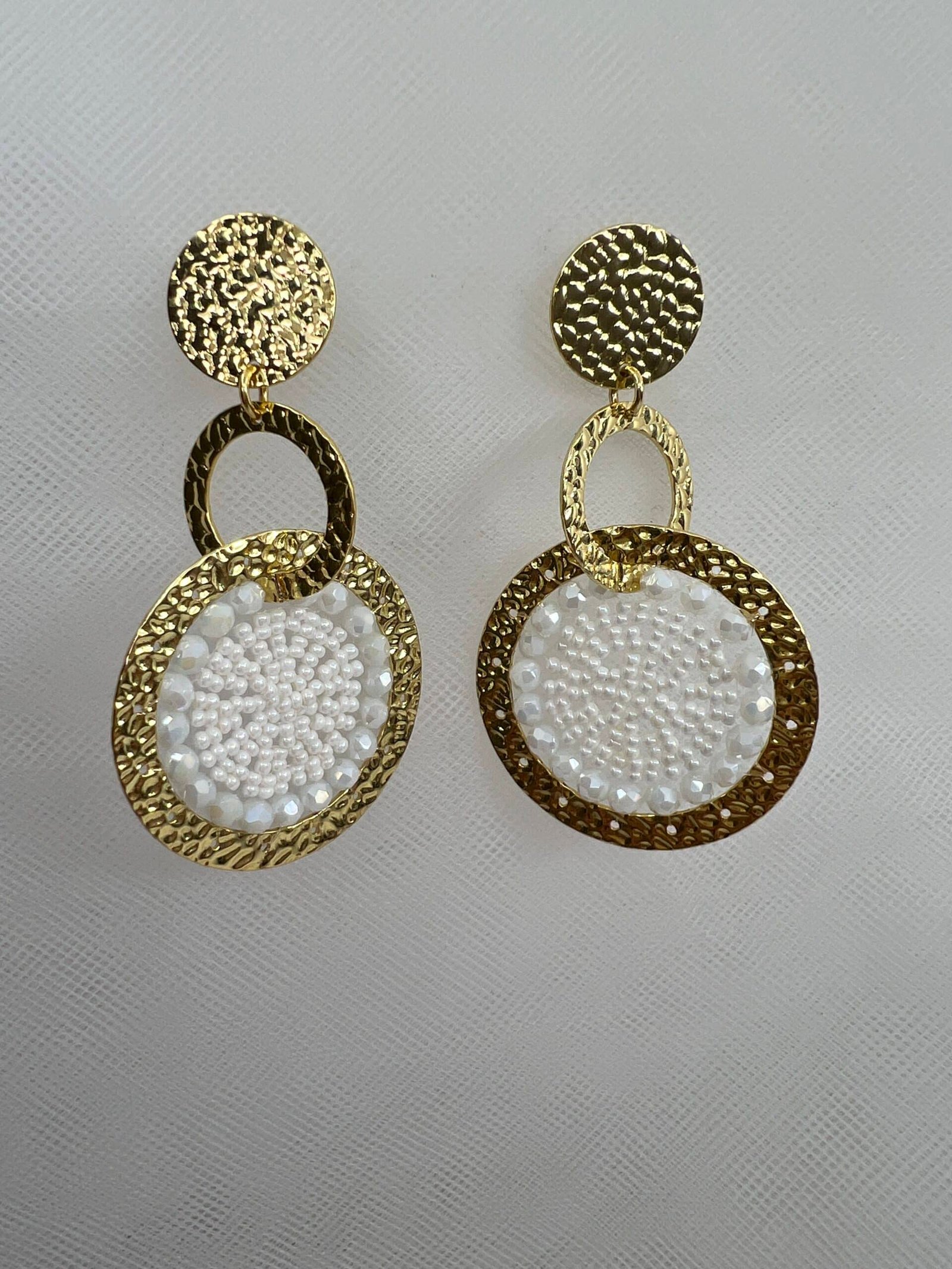 Pendientes largos de acero chapados con cuentas de cristal blancas.