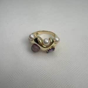 Anillo chapado en oro amarillo con circonita de color morado y perlas y piedra naturales.
