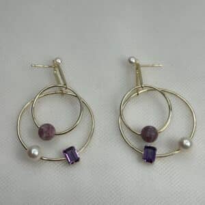 Pendientes largos de plata chapados en oro amarillo con perlas y piedras naturales y circonitas de color morado.
