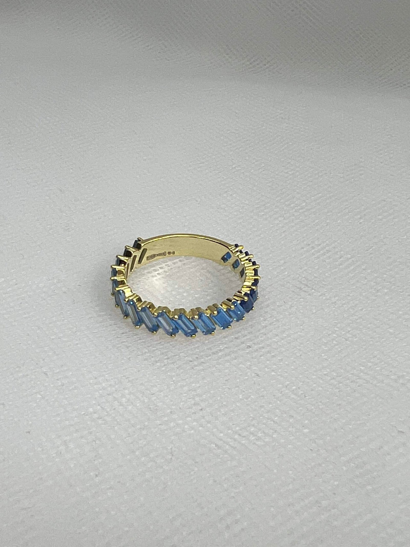 Anillo de plata chapado en oro amarillo con circonitas de tonos azules.