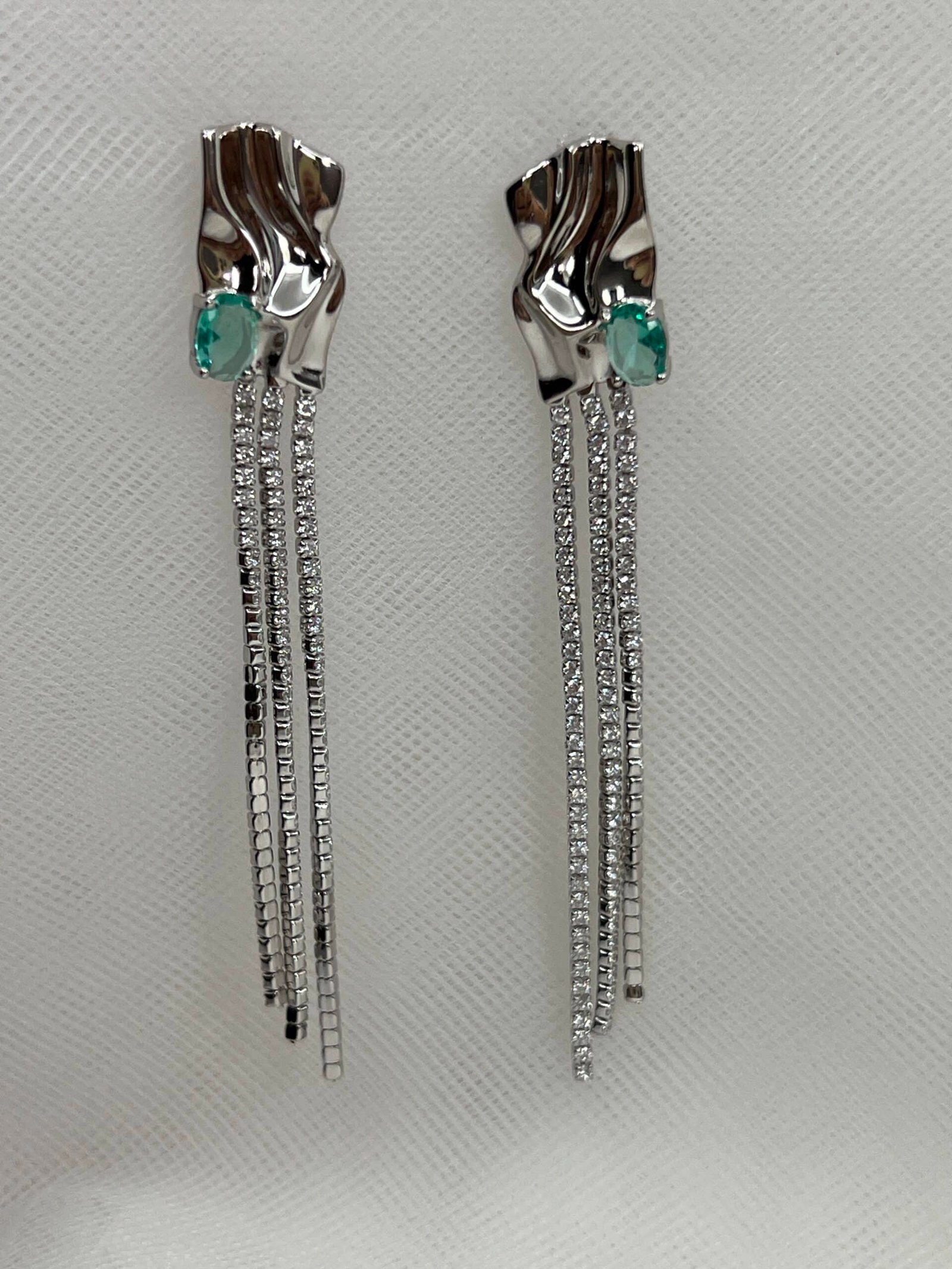 Pendientes largos de plata rodiados en oro blanco boton ondulado con circonita verde y cadenas con circonitas.