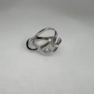 Anillo de plata rodiado en oro blanco con circonita de color azul.