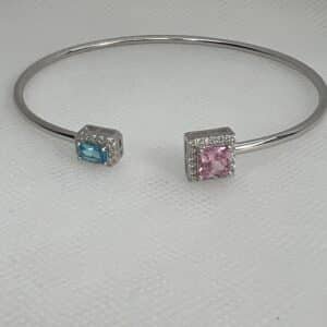 Esclava de plata rodiada en oro blanco abierta en el centro con circonitas azul,rosa y blancas.