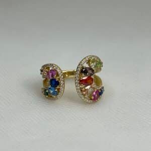 Anillo de plata chapado en oro amarillo abierto por el centro con circonitas de colores y blancas.