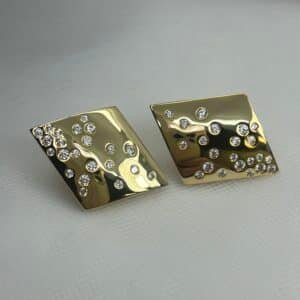 Pendientes de plata chapados en oro amarillo con circonitas de distintos tamaños engastadas aleatoriamente.