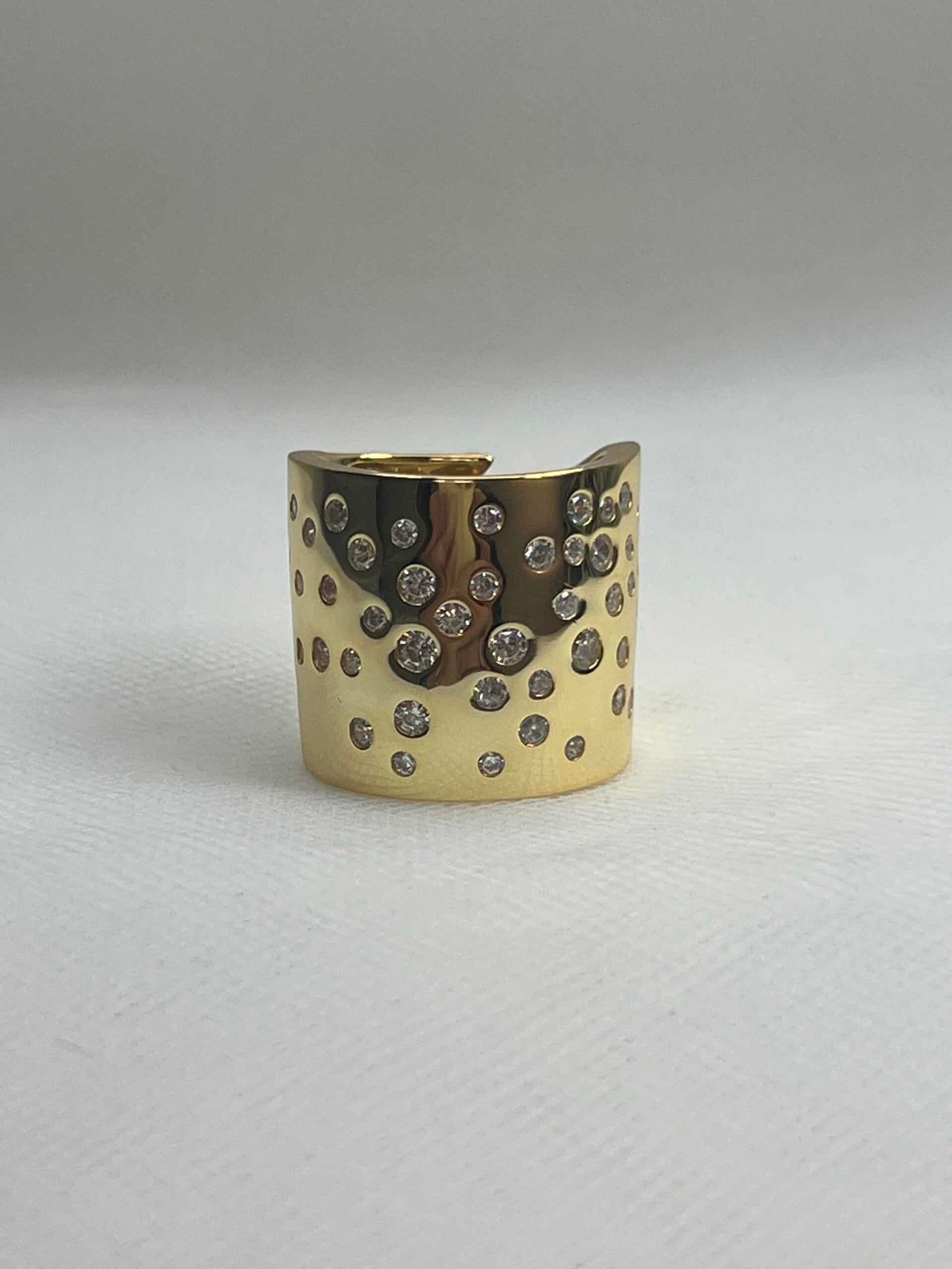 Anillo XL de plata  chapado en oro amarillo brazo ancho ajustable con circonitas engastadas de distintos tamaños.