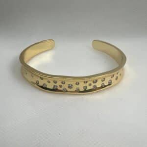 Esclava abierta de plata chapada en oro amarillo con circonitas engastadas de distintos tamaños.