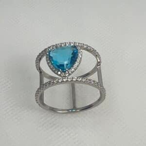 Anillo de plata rodiado en oro blanco con circonitas y circonita azul.