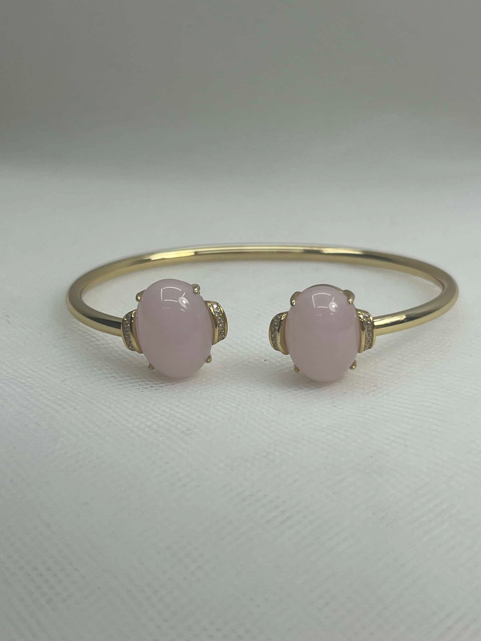 Esclava de plata chapada en oro amarillo abierta en el centro con cuarzo rosa natural y circonitas.