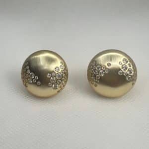 Pendientes  de plata chapados en oro amarillo medias bolas matizadas con circonitas engastadas de distinto tamaño.