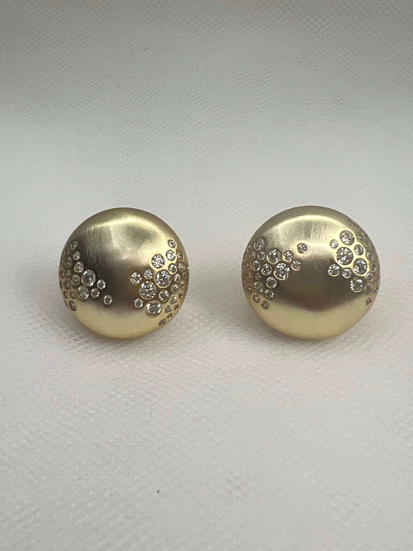 Pendientes  de plata chapados en oro amarillo medias bolas matizadas con circonitas engastadas de distinto tamaño.